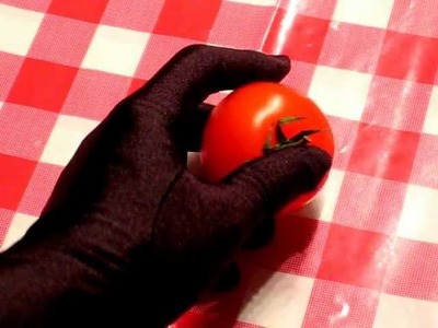 Squeezing a tomato with black satin glove
