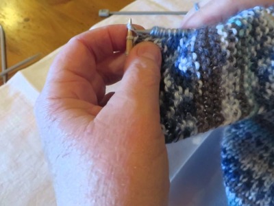 Knitting up stitches to complete a bed sock.