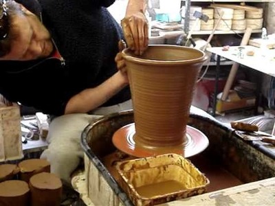 Throwing making a Terracotta Clay Long Tom Flower. Plant Pot on the Wheel