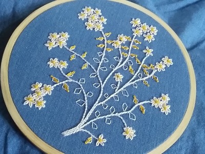 Hand embroidery of yellow and white lazy daisy flowers