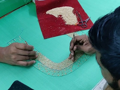 Two artisans working on a scattered bead embroidery