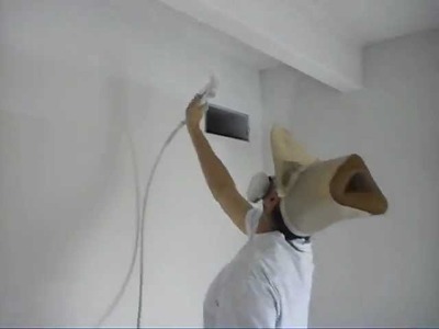 Doug Bloom spray painting a ceiling while wearing a homemade masking paper hat