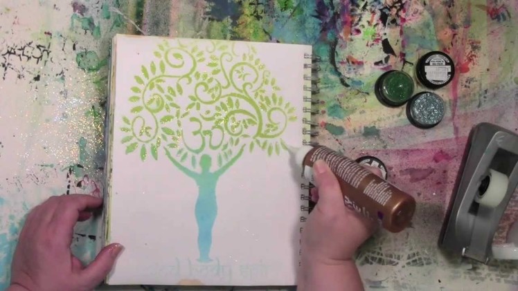 Stencils and spray inks with a touch of glitter in an art journal
