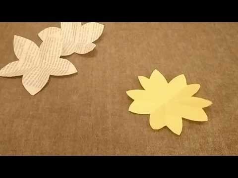 Folding a square piece of paper to cut a five petal flower