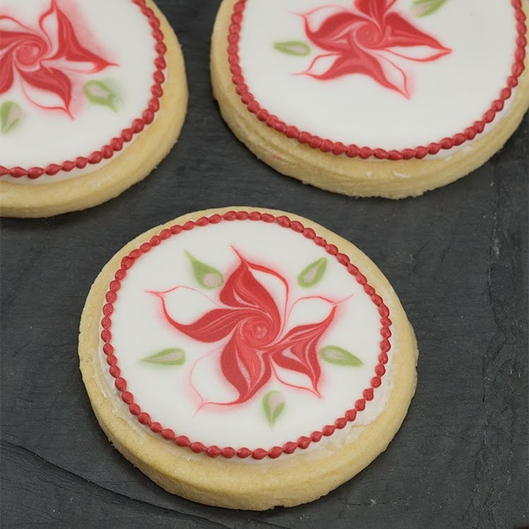 Learn How to Pipe a Wet on Wet Poinsettia on a Sugar Cookie