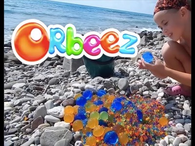 Throwing giant water balz jumbo polymer balls at the sea shore.