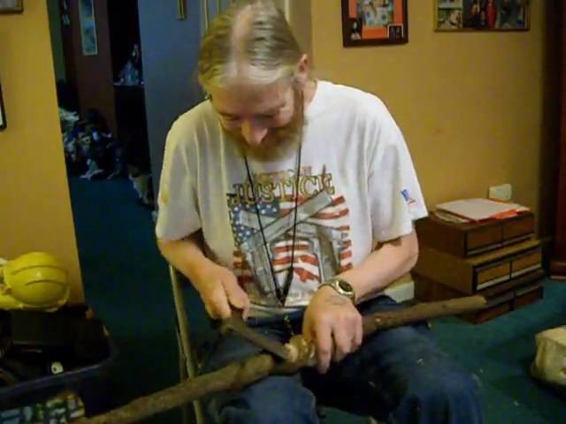 1 of 2 carving a snake on a walking stick