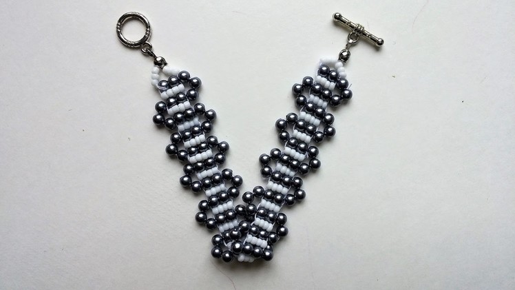 SIMPLE BEADED PATTERN for BEGINNERS. A bracelet of white seed beads and black pearl beads.