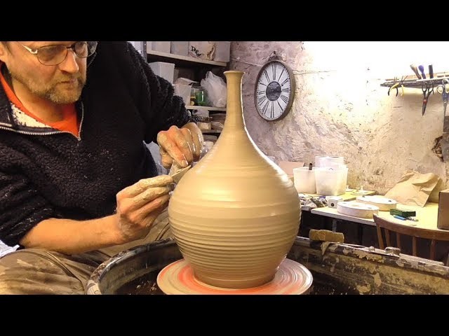 Making. Throwing a Tall Neck Pottery Vase on the Wheel.