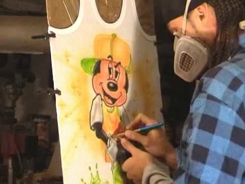 Cee airbrushing Mickey Mouse in Nike Dunk on a T-shirt