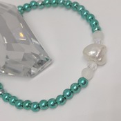 Cultured freshwater keshi pearl with teal green and frosted white beads on a stretch elastic thread bracelet