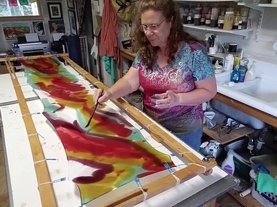 Hand painting a silk scarf.