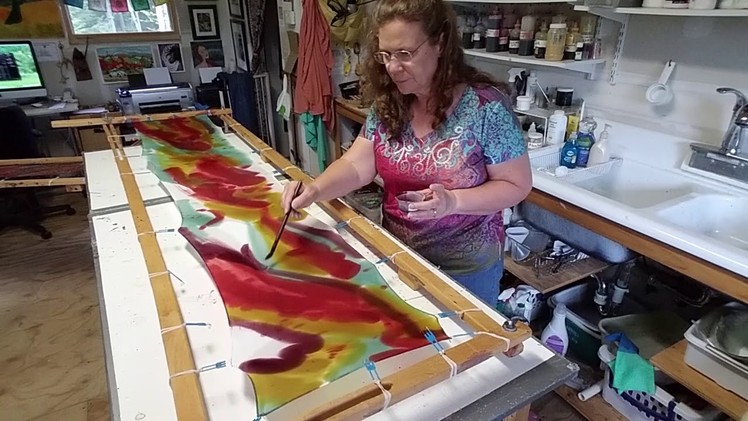 Hand painting a silk scarf.