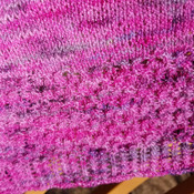 Knitted shawl in beautiful tones of pinks and purples using a blend of 50 percent baby alpaca and 50 percent merino wool. Gorgeous