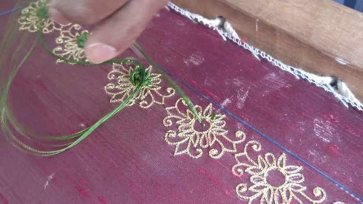 Can you name the embroidery technique used to create the green flower