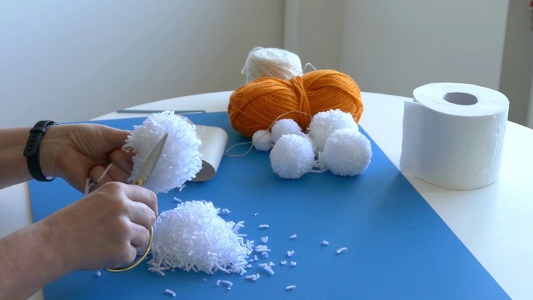 Making pom poms using toilet paper roll core