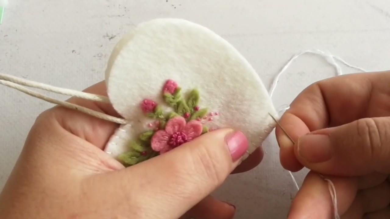 Buttonhole stitching on white floral heart ornament